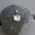 Gold pendant with a moonstone on a rock