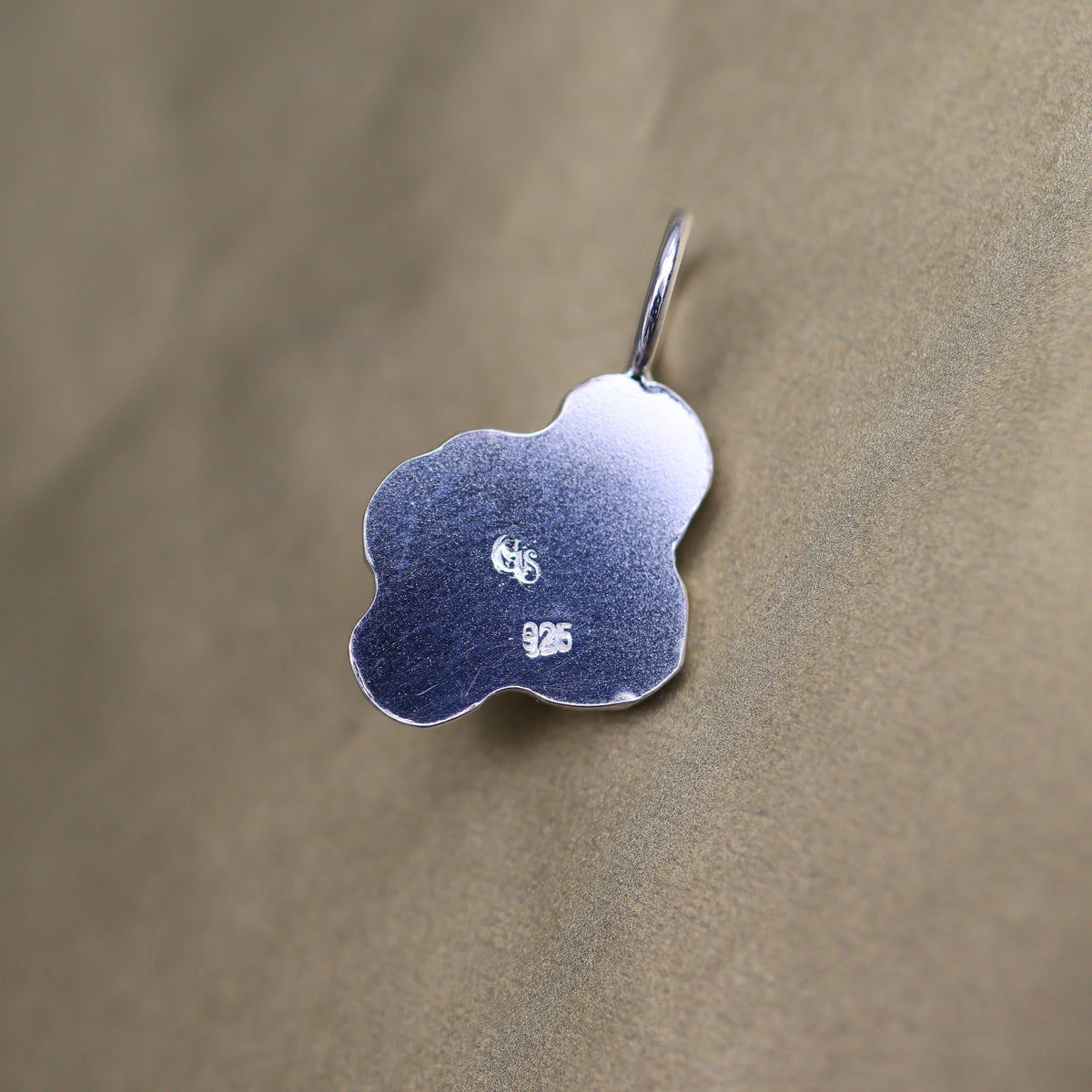 back of a silver pendant with quality and makers mark stamps