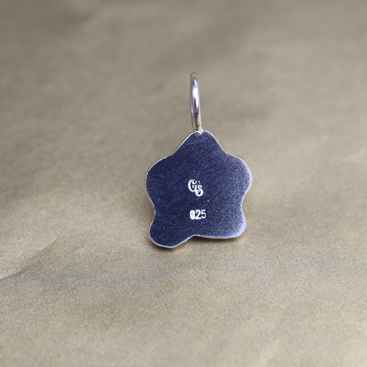 back of a sterling silver pendant showing quality and makers mark stamps