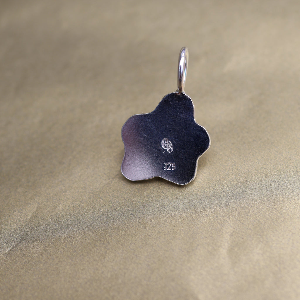 the back of a silver pendant with quality and makers mark stamps