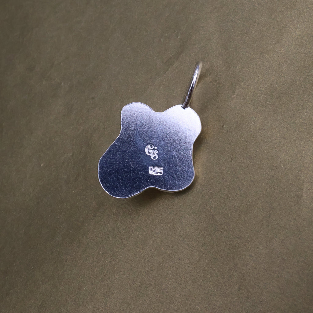 the back of a silver pendant with quality and makers mark stamps