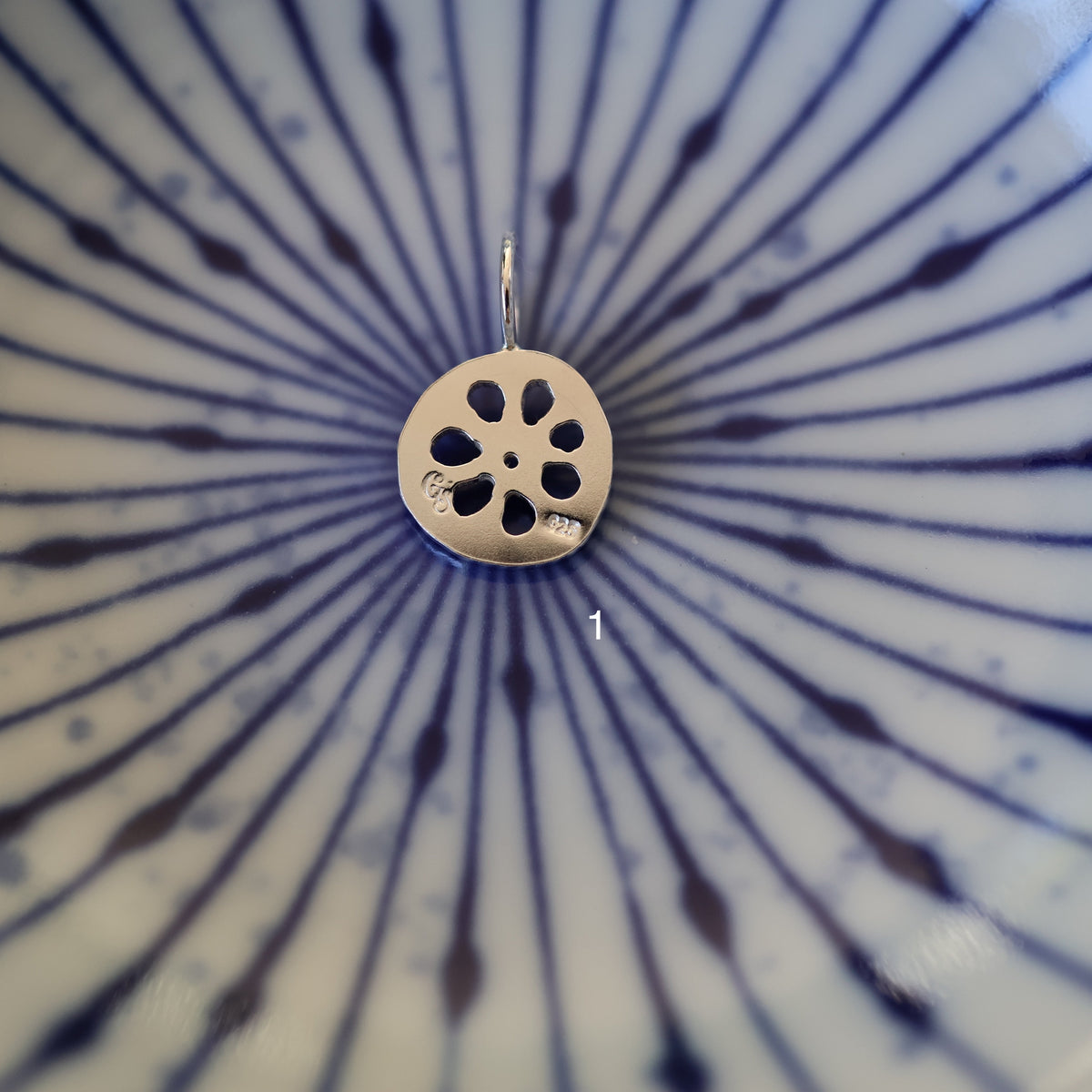 the back of a silver lotus root pendant with quality and maker's mark stamps