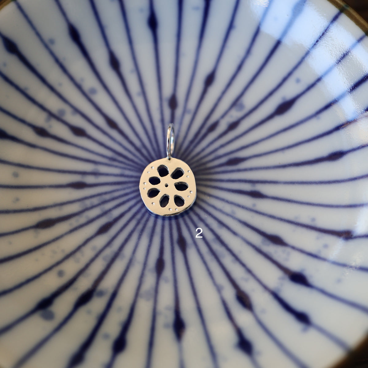 a silver lotus root charm labeled '2'