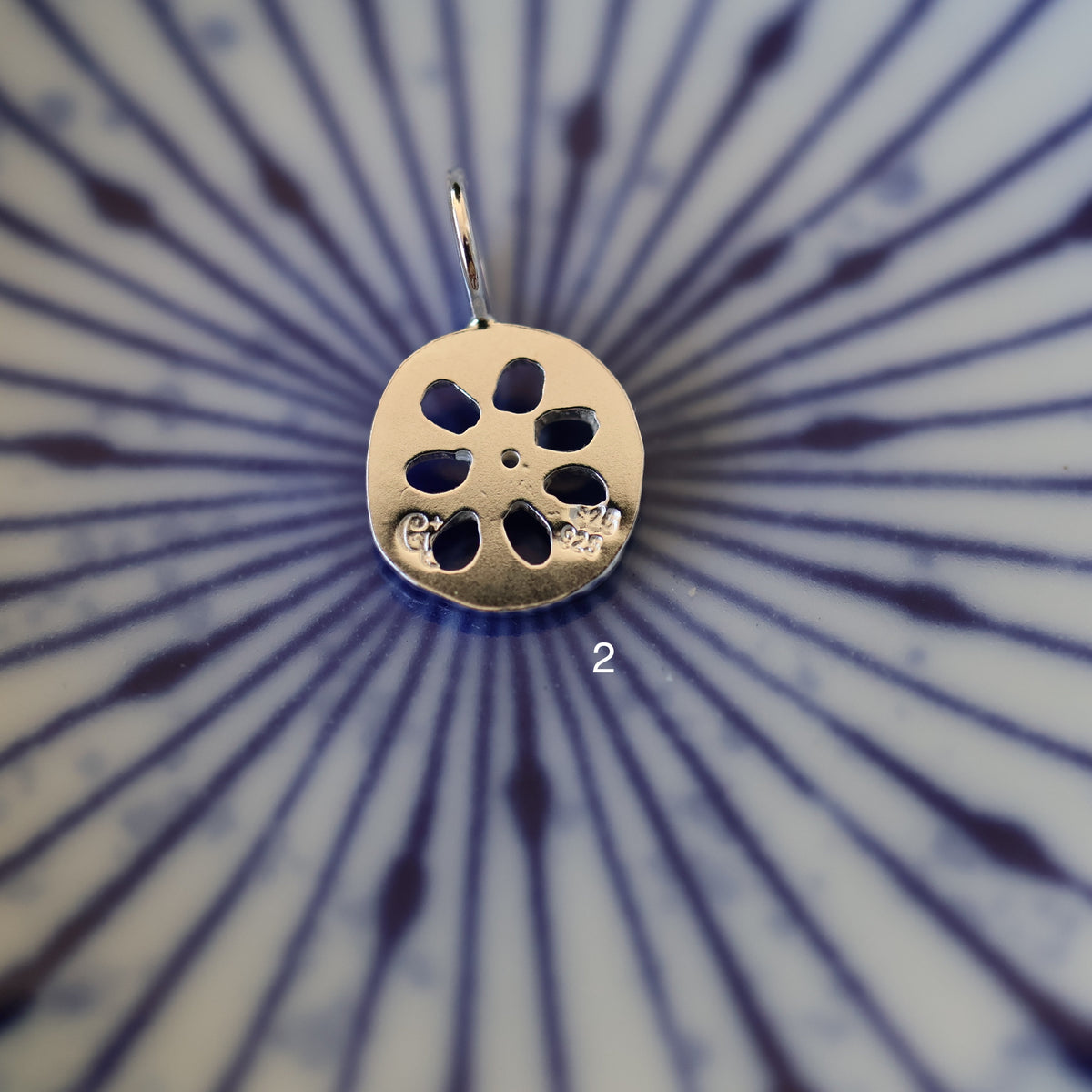 the back of a silver lotus root pendant with quality and maker's mark stamps
