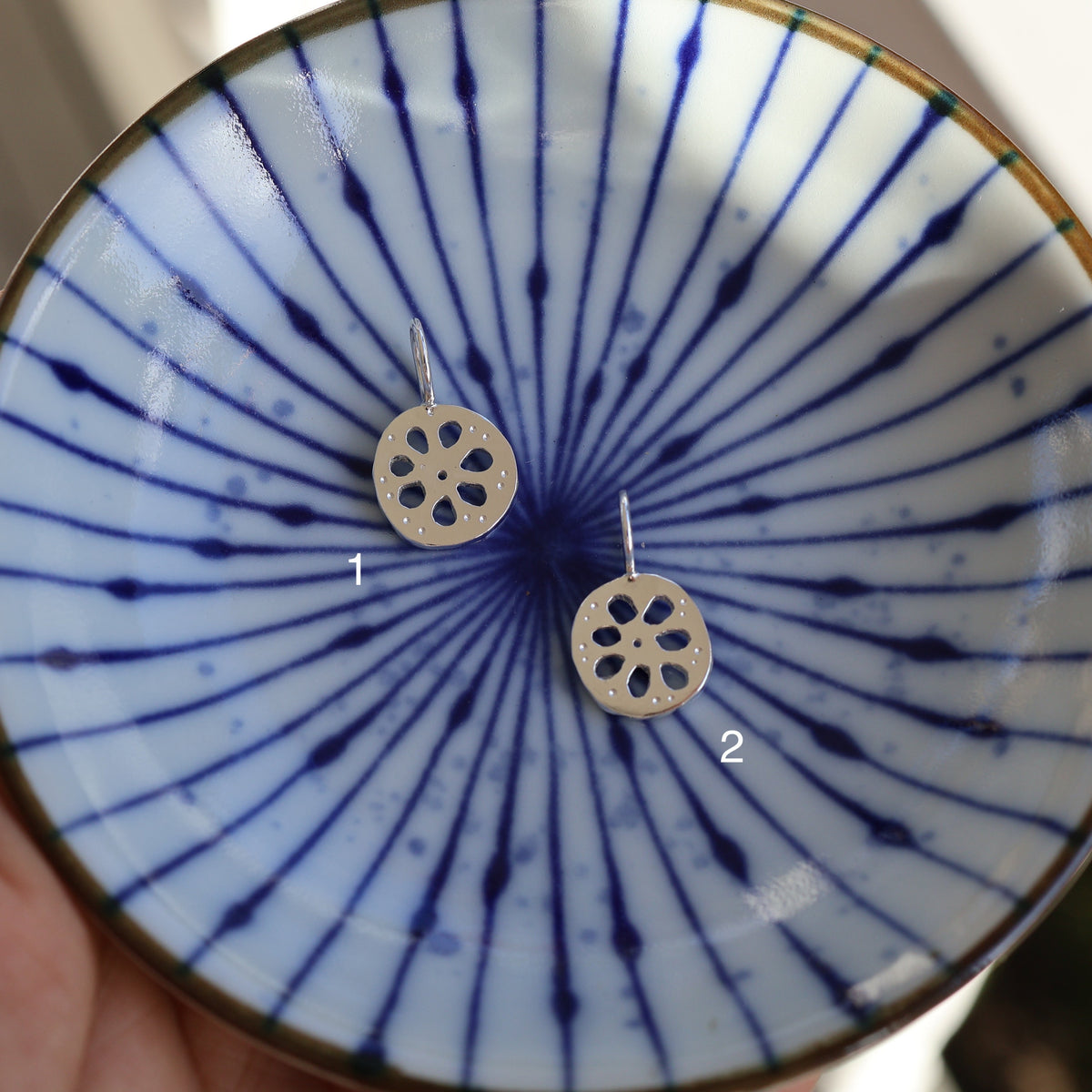 2 lotus root pendants in a blue ceramic dish