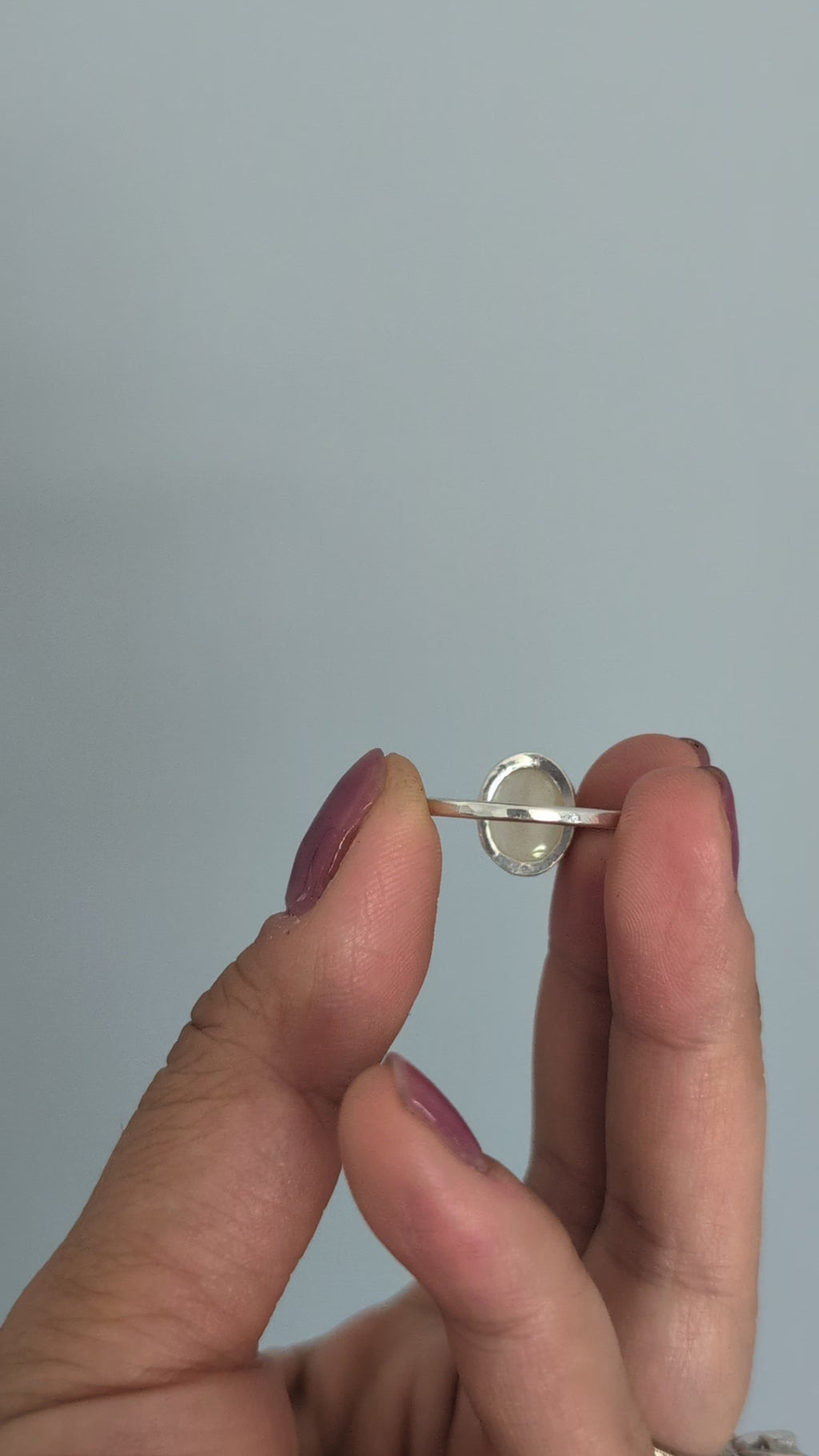 Hand holding a ring with a colorful Ethiopian opal