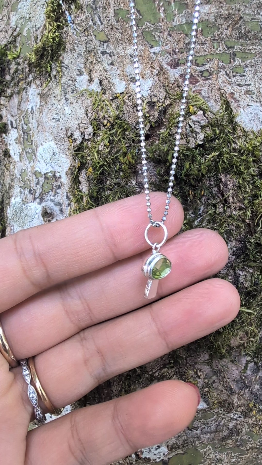 Silver mushroom shaped pendant with a green gemstone